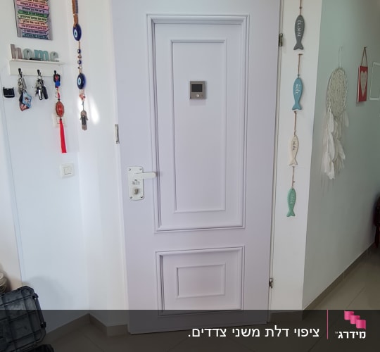 דלת לבנה עם ידית כסופה, כלי עבודה על הרצפה